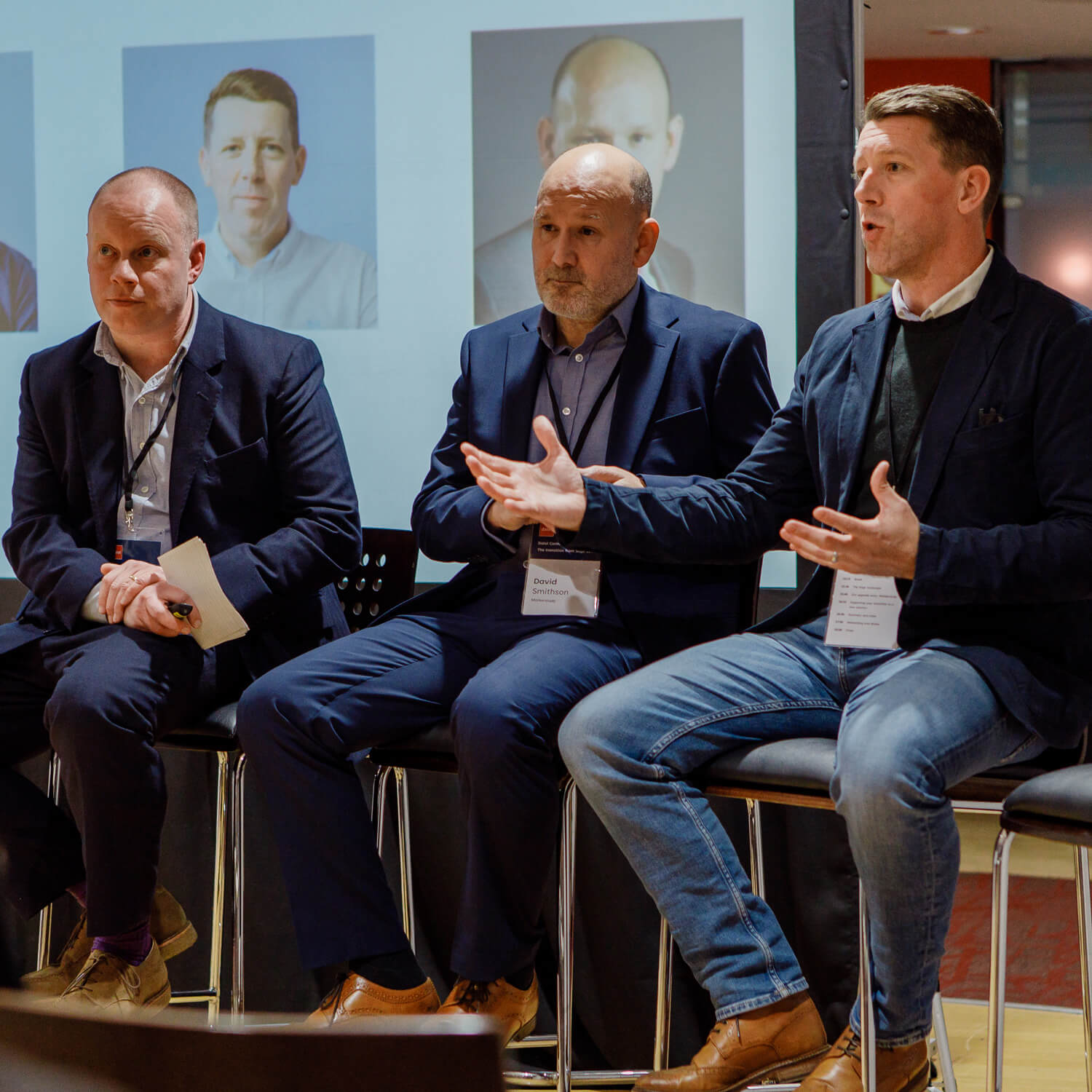 Three suited men giving a presentation