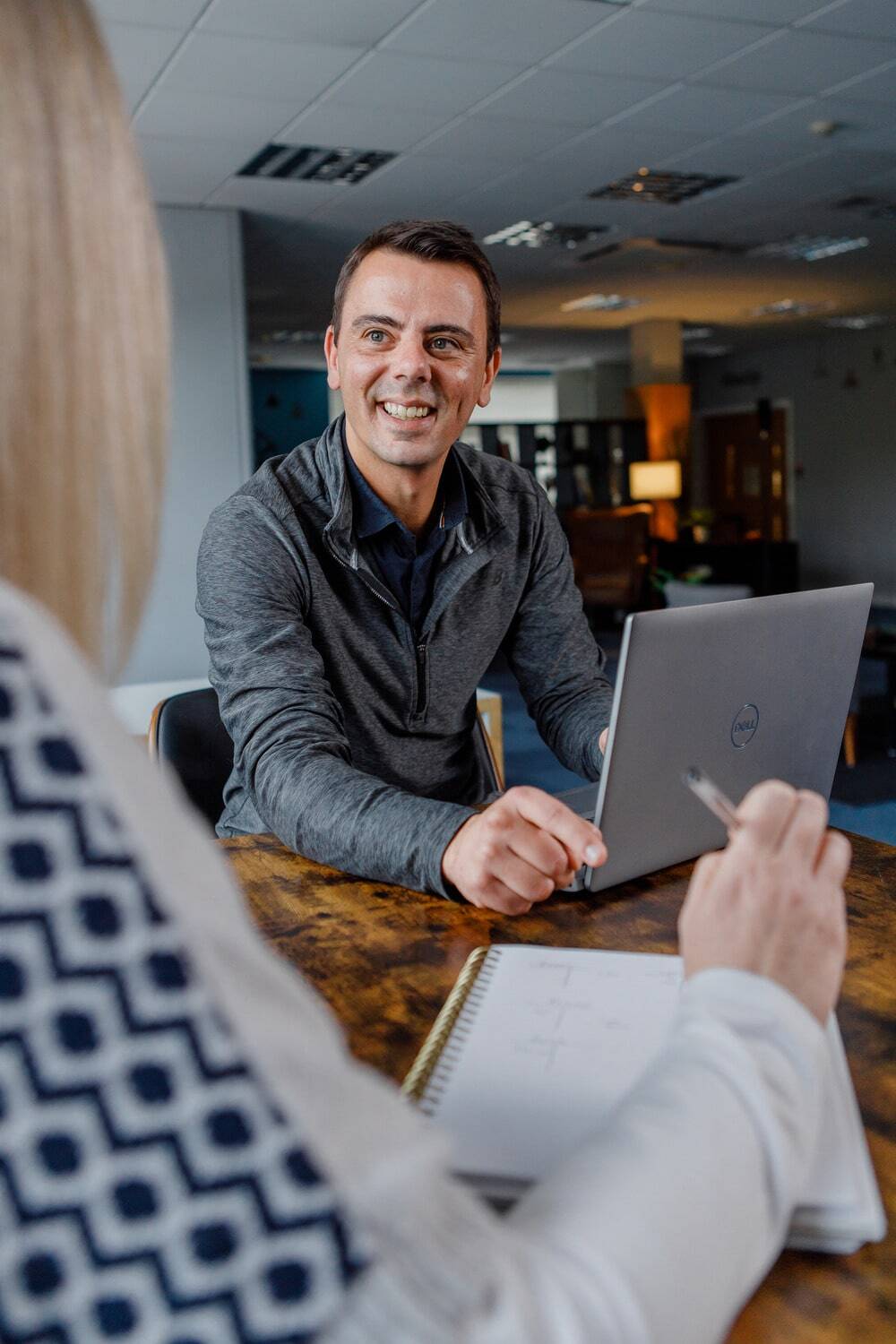 A man smiling with a laptop