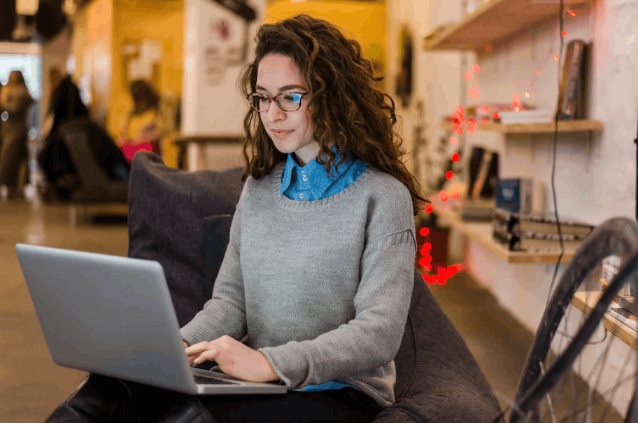 A woman sat with a laptop on her knee